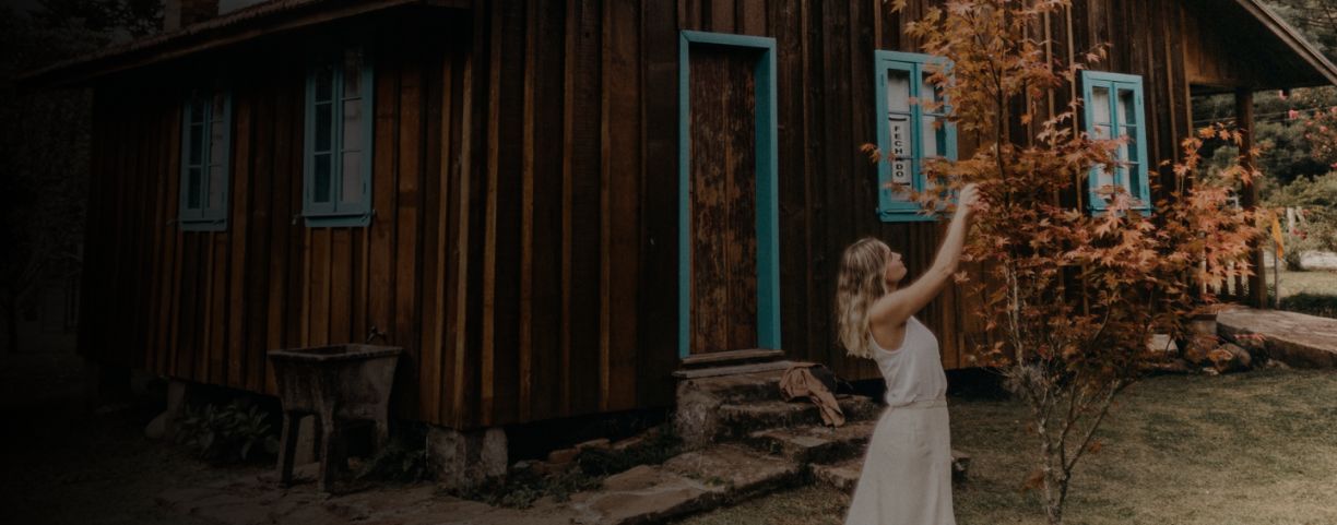 Vrouw in witte jurk bij vakantiehuis